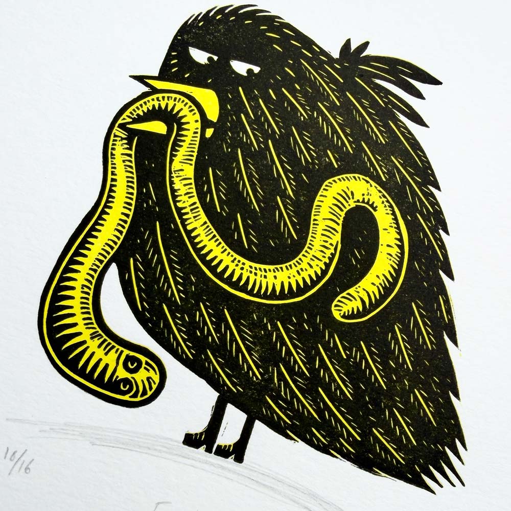 Early Bird handmade linocut print showing a black bird holding a yellow worm by Tigerlino